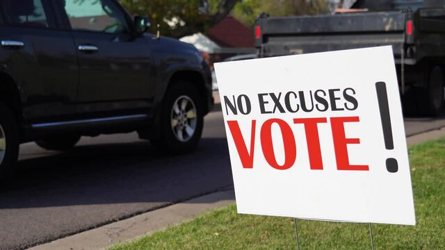 Political Voter Rally Sign Next to Road with Cars Driving By, No Excuses Vote! - Powered by Adobe