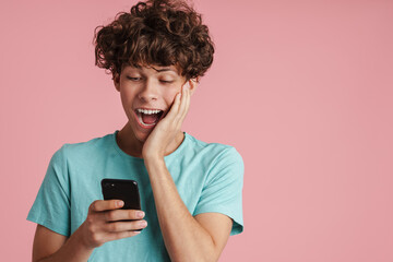 Smiling teenage boy holding mobile phone isolated