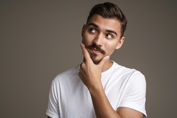 Image of thinking unshaven guy posing and looking upward