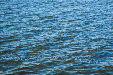 Texture of blue wavy water of the sea, ocean, rivers close-up.