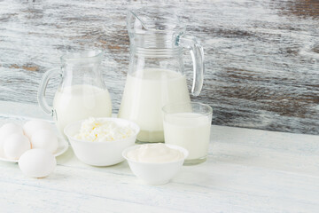 Different dairy products on the white wooden boards