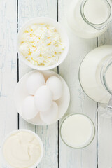Different dairy products on the white wooden boards
