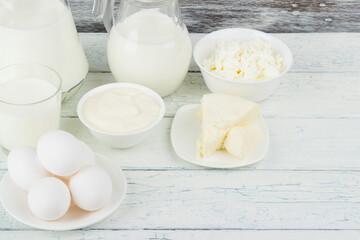 Different dairy products on the white wooden boards