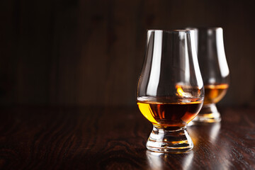 glass of whisky spirit brandy on dark brown background