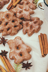 Ginger cookies, some spices and fir tree branch on the tablecloth.