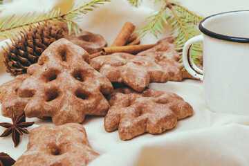 Ginger cookies, some spices and fir tree branch on the tablecloth.