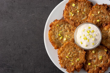Traditional Jewish latkes or potato pancakes on black stone.Top view