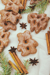 Ginger cookies, some spices and fir tree branch on the tablecloth.