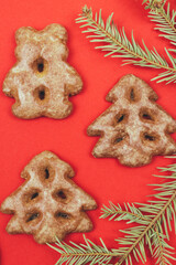 Ginger cookies and fir tree branch on a red background.