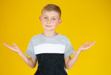 Little cute boy kid wearing casual t-shirt clueless and confused expression with arms and hands raised. doubt concept.