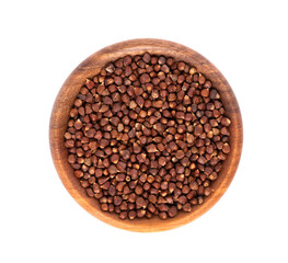 Guinea pepper grains in wooden bowl, isolated on white background. Melegeta, alligator pepper or mahlab. Grains of paradise. Top view.