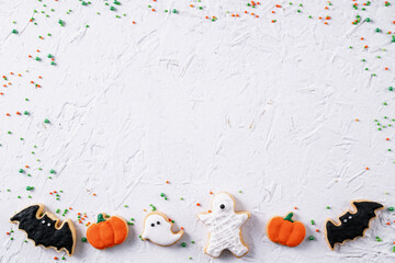 Top view of Halloween festive decorated icing sugar cookies on white background.