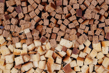 Pieces of roasted white and brown bread on a dark background. Close-up of delicious croutons.