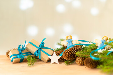 Two gifts for Christmas on a background of lights with fir branches.