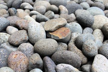 A broken pebble among stones in the garden.