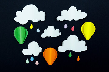 Cardboard clouds, raindrops and air balloons on the dark background. Balloons in the night sky with raindrops and clouds.