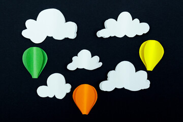 Cardboard clouds and air balloons on the dark background. Balloons in the night sky with clouds.