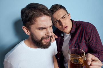 Two cheerful drunk friends drinking beer lifestyle emotions on a blue background
