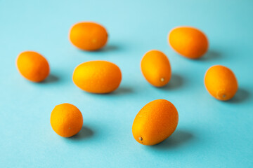 orange kumquat fruit on blue background