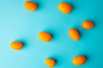 orange kumquat fruit on blue background