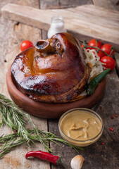 Pork eisbein on a wooden background with vegetables and sauerkraut, mustard and fresh vegetables....