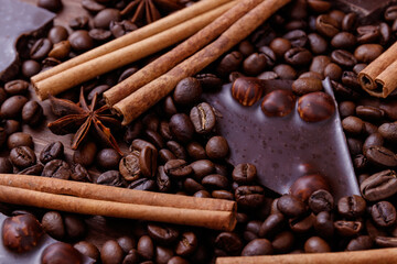 Chocolate bar with nuts on a wooden table with coffee beans and spices. Roasted coffee beans,...