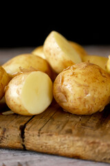 Fresh raw potatoes on a wooden surface.