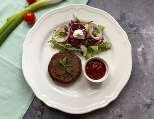 Fried mince patties, also know as rissoles. The side dish is a Greek style salad with colorful vegetables, mixed greens, red onions, cucumber, tomato, crumbly feta cheese and vinaigrette.