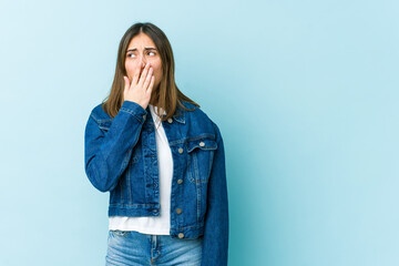 Young caucasian woman yawning showing a tired gesture covering mouth with hand.