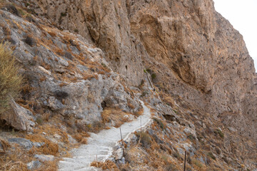 Tourist on the mountain path, Thira island, Greece.