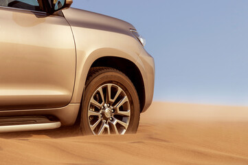 Fototapeta na wymiar Close up of a golden car stuck in the sand in the Namib desert.