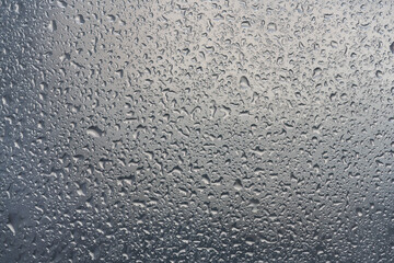 water drops on glass background texture. rain on the grey window
