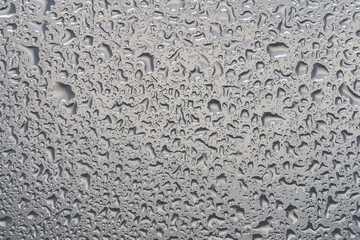 water drops on glass background texture. rain on the grey window