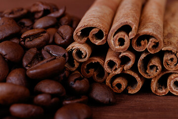 Obraz na płótnie Canvas Cinnamon sticks closeup on dark wood background with roasted coffee beans.