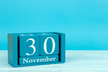 wooden calendar with the date of November 30 on a blue wooden background, Pet Day; International Information Protection Day; International Skirt Day; International Day 