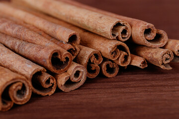 Cinnamon sticks closeup on dark wood background.
