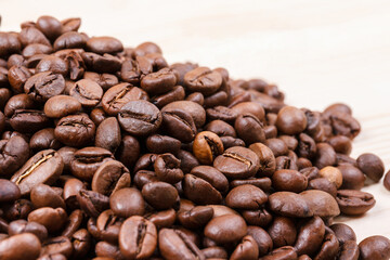 Fresh roasted coffee beans on wooden table. Macro shot.