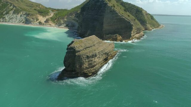 Majestic Oceanic Rock Formation sticks out of beautiful tropical turquoise waters Morro, Drone Aerial