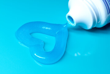 A heart made of blue toothpaste. gel toothpaste in a shape of a heart on blue. good morning, good...