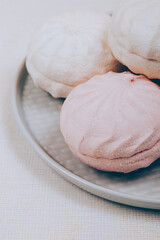 Tasty sweet zephyr on a plate and tablecloth background.