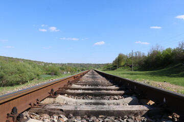 Rails, clear skies and green surroundings