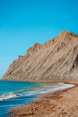 Fototapeta na wymiar Sunny landscape of seaside shore with view of sandy beach, waves, cape Chameleon. Black Sea, Crimea