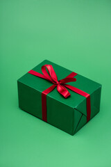 colorful gift box with red ribbon on green background