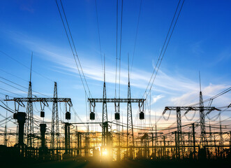 High-voltage power lines at sunset or sunrise. High voltage electric transmission tower