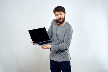 A man in a gray sweater with a laptop hands lifestyle technology communication internet work