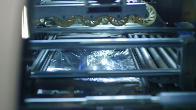 Mushroom packing conveyor belt. White mushrooms in plastic containers move inside the machine when packed in plastic wrap. Mushroom farm, Food industry Automated assembly line.