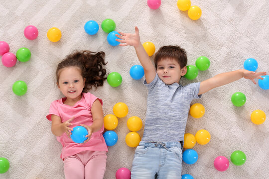 Cute Little Children With Toys On Floor Indoors, Top View