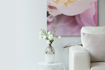 Vase with fresh flowers on white table in living room