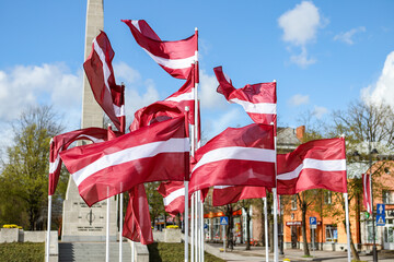 Multiple Latvia flags waving in wind.