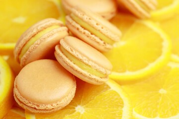 Set of Many tasty macarons on bright orange fruit background. a pattern of colorful french cookies. homemade food.